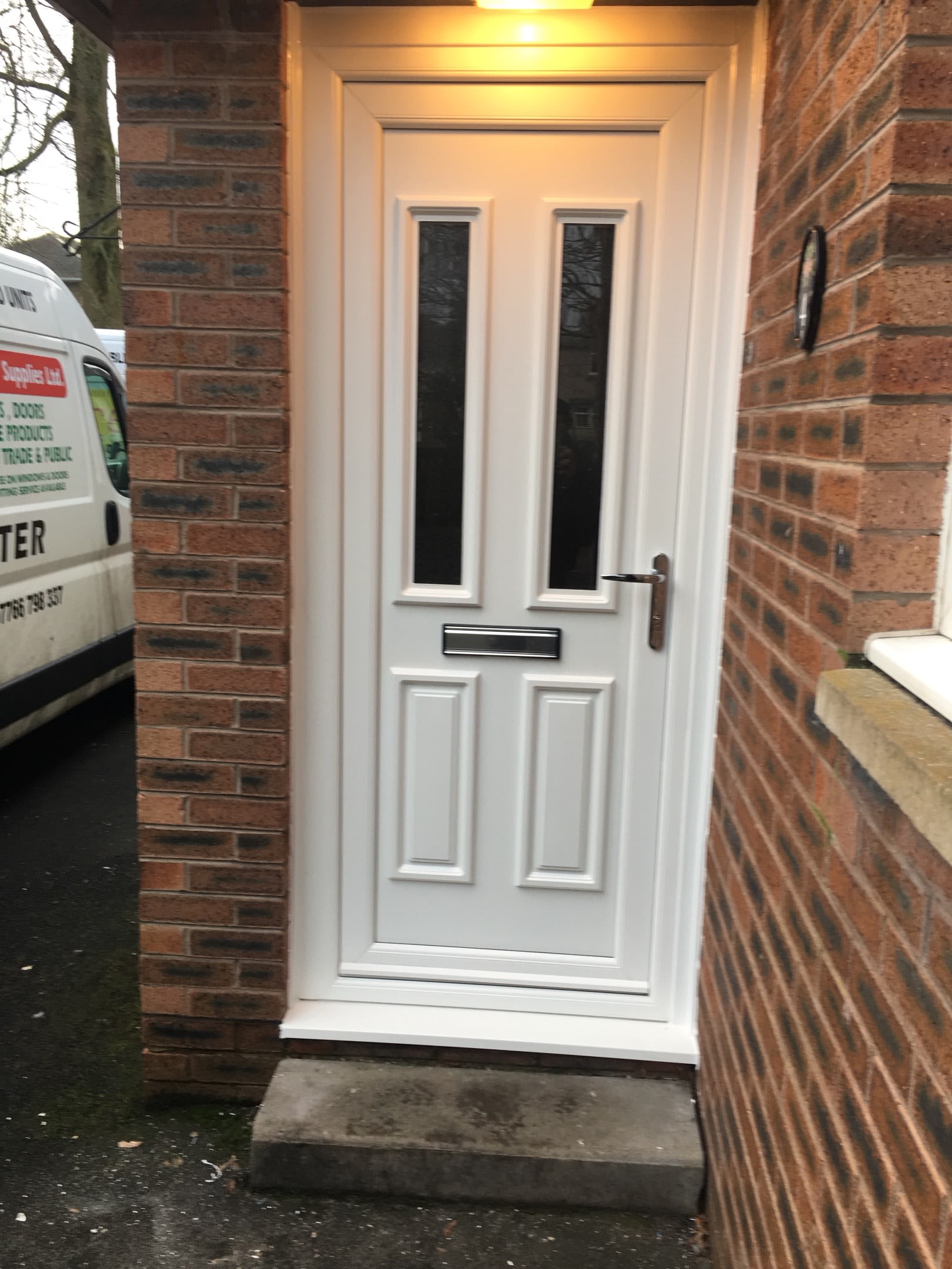 White glazed entrance with matching side panels.